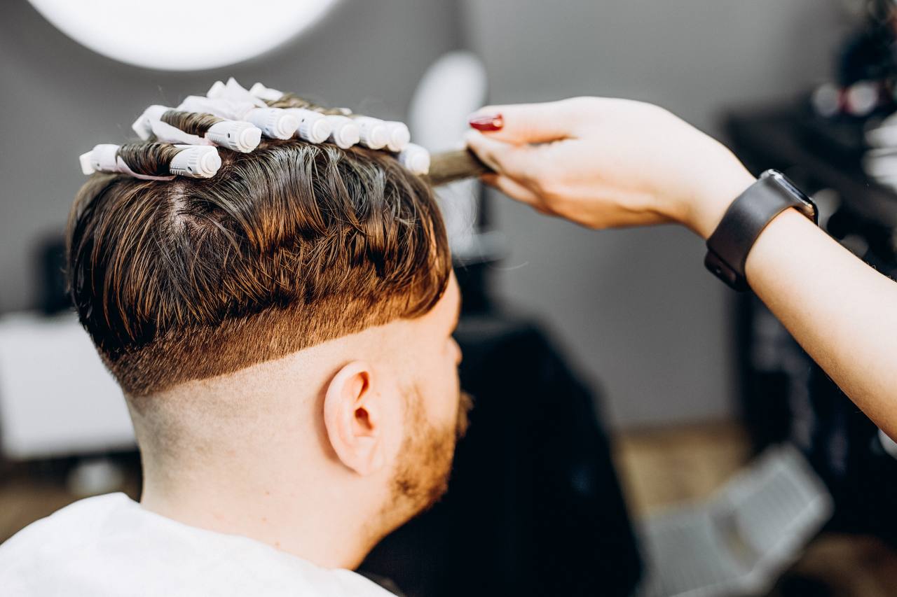 Barber nawija włosy na wałki podczas trwałej ondulacji męskiej – BRODSKI Barbershop Wilanów