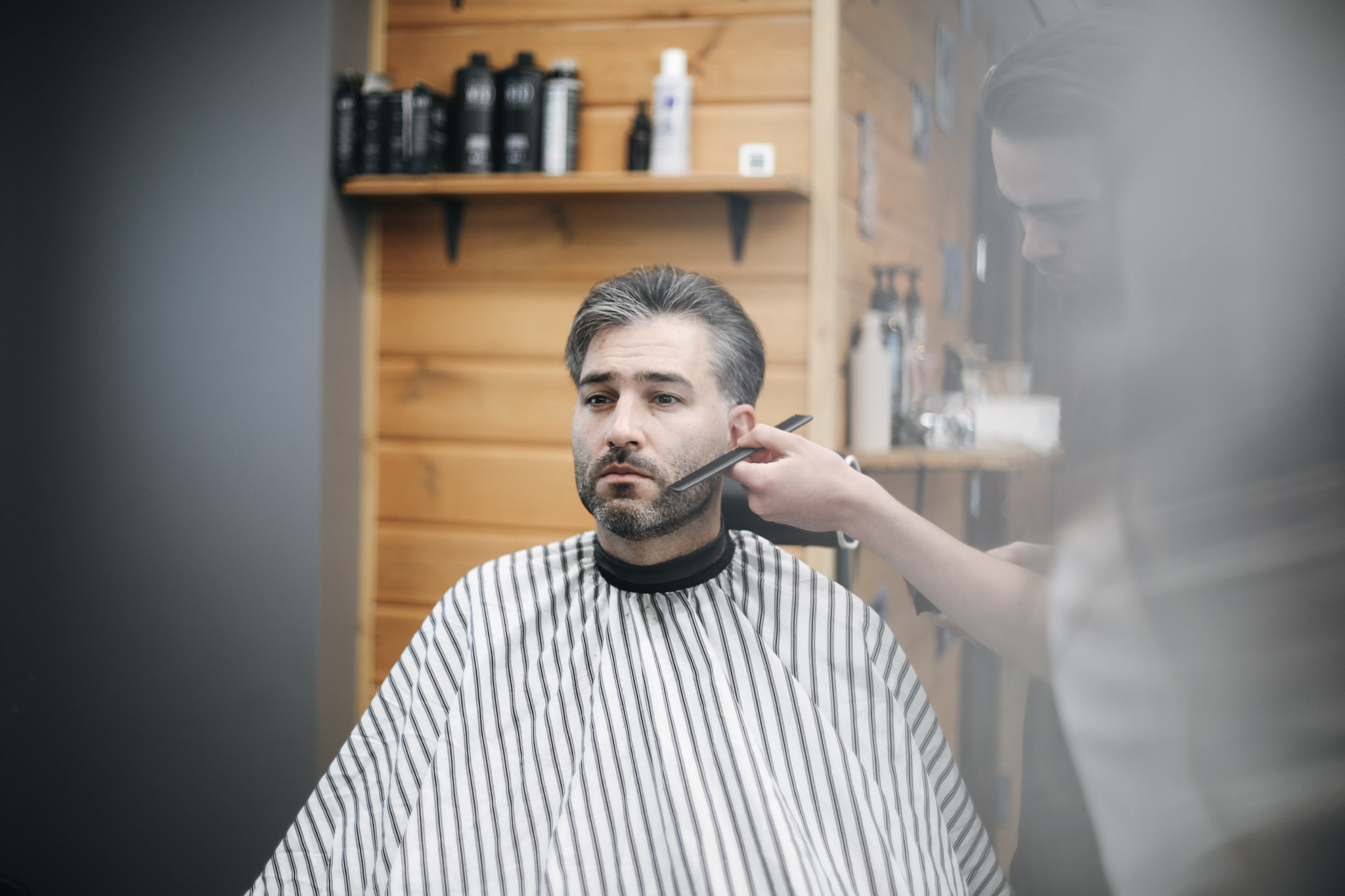Barber at BRODSKI barbershop consulting with client before beard trimming, marking jawline shape in Wilanów Warsaw