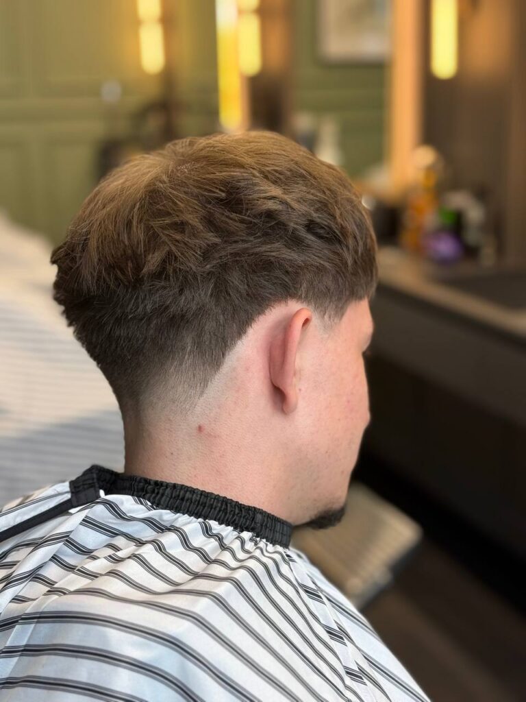 Męskie strzyżenie taper fade z teksturowaną górą w BRODSKI Barbershop przy Al. Rzeczypospolitej w Wilanowie