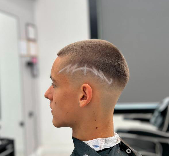 Hair tattoo – wzór wygolony nad uchem, buzz cut i skin fade, widok z profilu – Łukasz, barber BRODSKI, Wilanów