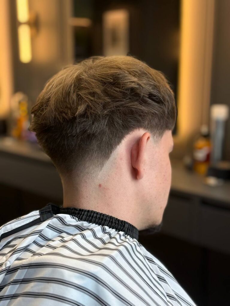 Low taper with textured top, back view showing neckline detail, by barber Denis at BRODSKI Barbershop Wilanów, Warszawa