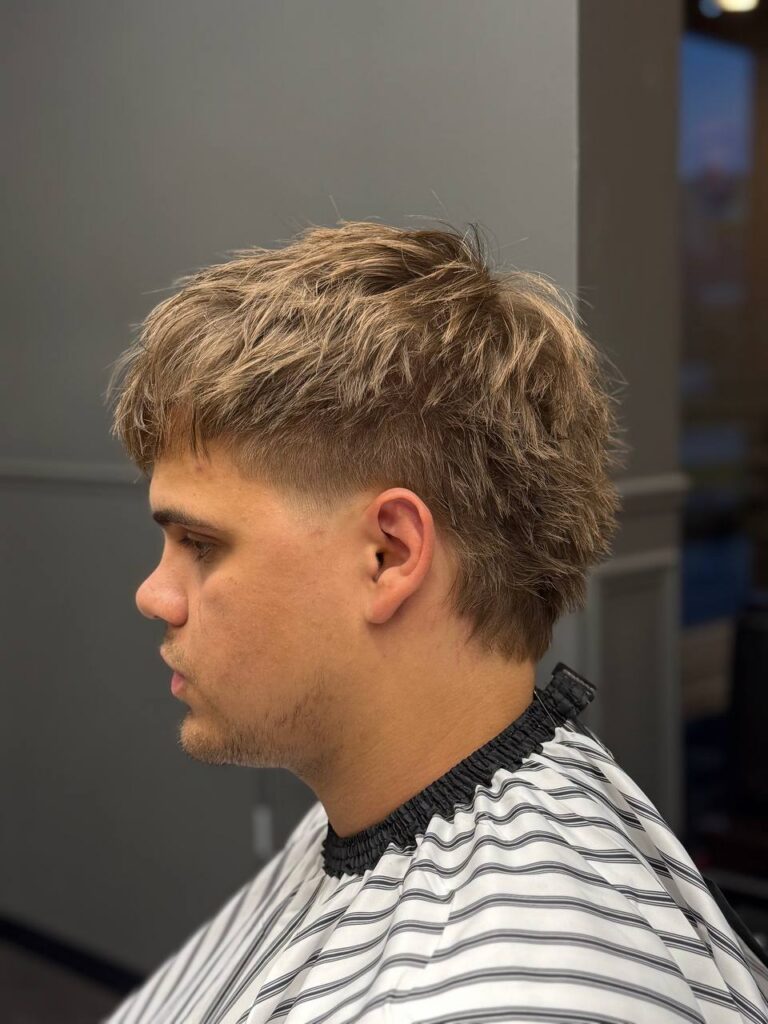 Taper fade crop z teksturowaną górą i dłuższym tyłem, widok z profilu – barber Denis, BRODSKI Al. Rzeczypospolitej 12, Wilanów