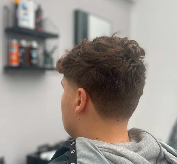 Teksturowany crop z falującą górą i wysokim skin fade na karku, widok z tyłu – Łukasz, barber BRODSKI, Wilanów