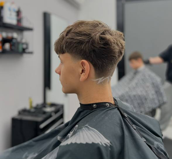 Teksturowany crop z low taperem i wygoloną linią na karku, widok z tyłu – Łukasz, barber BRODSKI, Wilanów