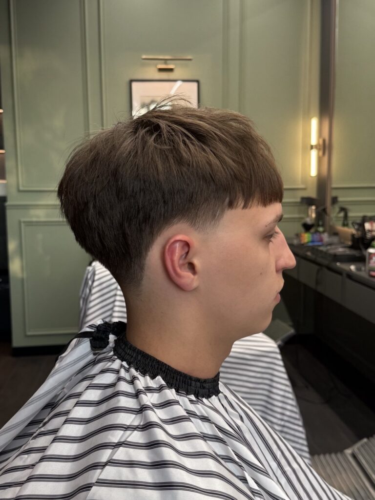 Textured crop with blunt fringe and low taper, profile view, by barber Denis at BRODSKI Barbershop Wilanów, Warszawa
