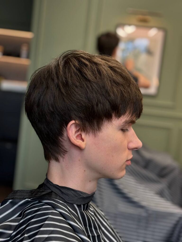 Textured crop with blunt fringe and mid taper, profile view, by barber Denis at BRODSKI Barbershop Wilanów, Warszawa