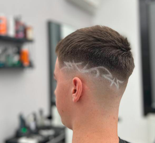 Rozbudowany wzór na włosach wygolony na boku, krótki crop i mid skin fade – Łukasz, barber BRODSKI, Wilanów